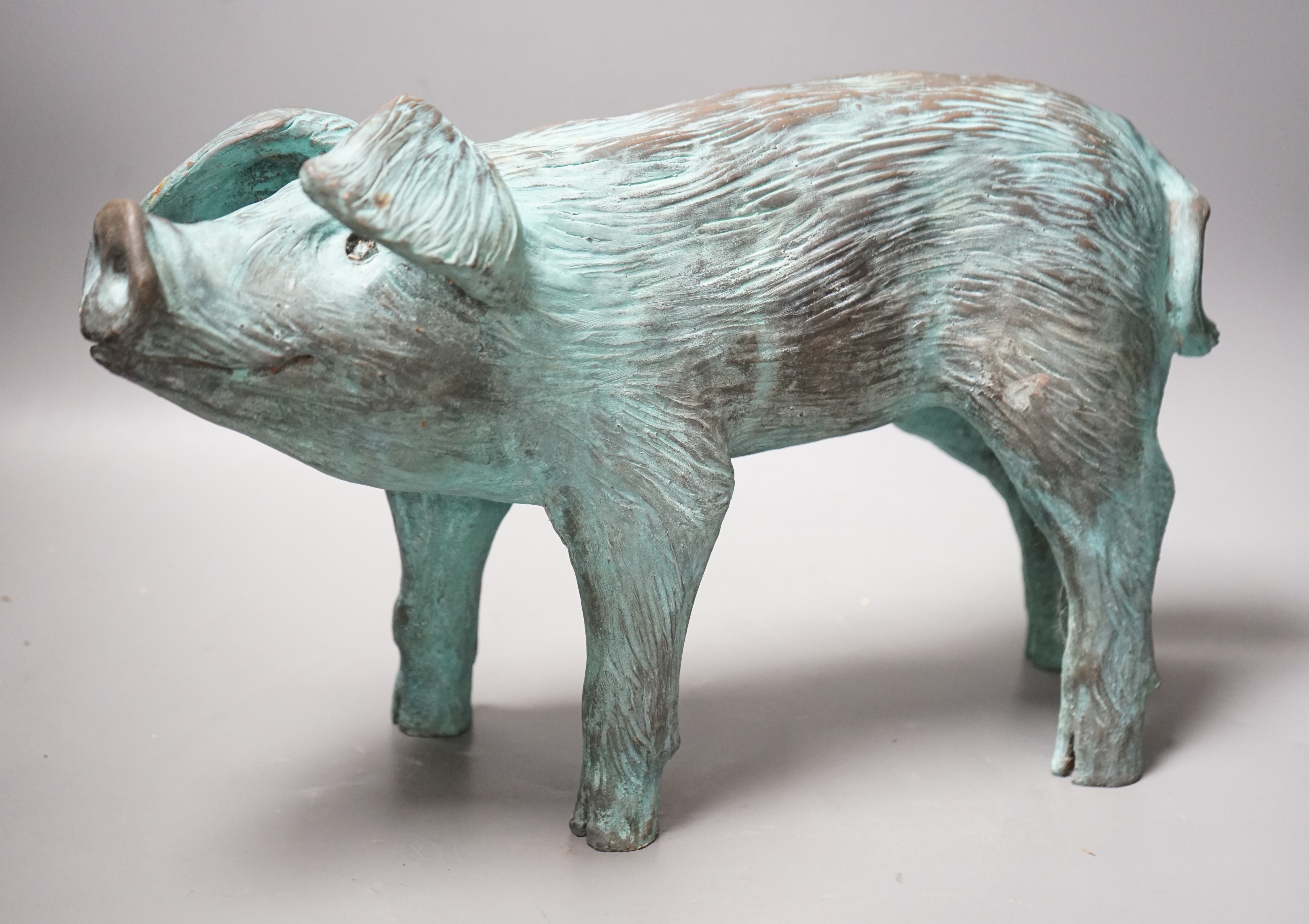 A cold cast resin bronze pig initialled 'JP', 40cm wide